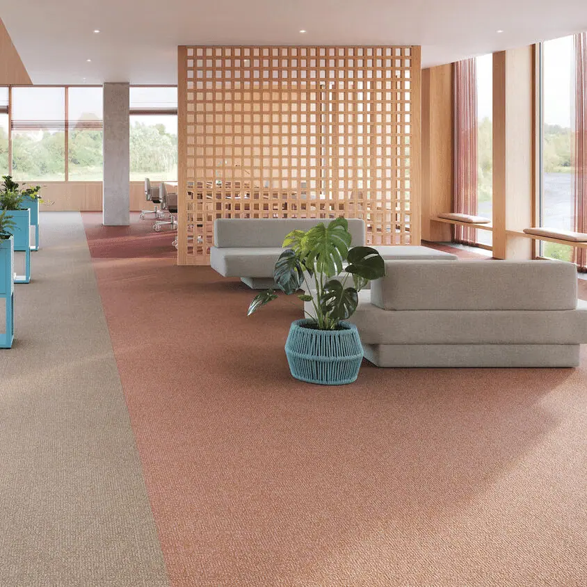 Desso Enlaced tapijttegels in de kleuren 9096, 5311, 2083 en 4311, gelegd in een open kantoorruimte met moderne zithoeken en natuurlijke lichtinval