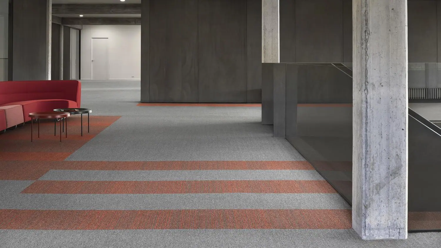 Moderne kantoorruimte met DESSO Essence tapijttegels in grijstinten en subtiele streeppatronen, geschikt voor commerciële interieurs.