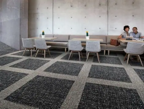 Lounge met Interface-tapijttegels in een patroon van donkere vlakken