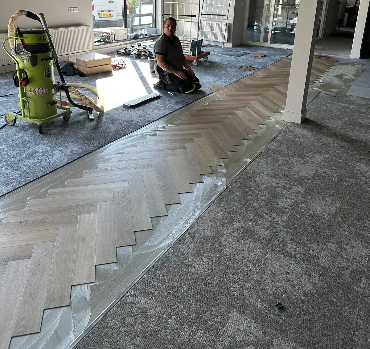Stoffeerder legt een PVC visgraatvloer