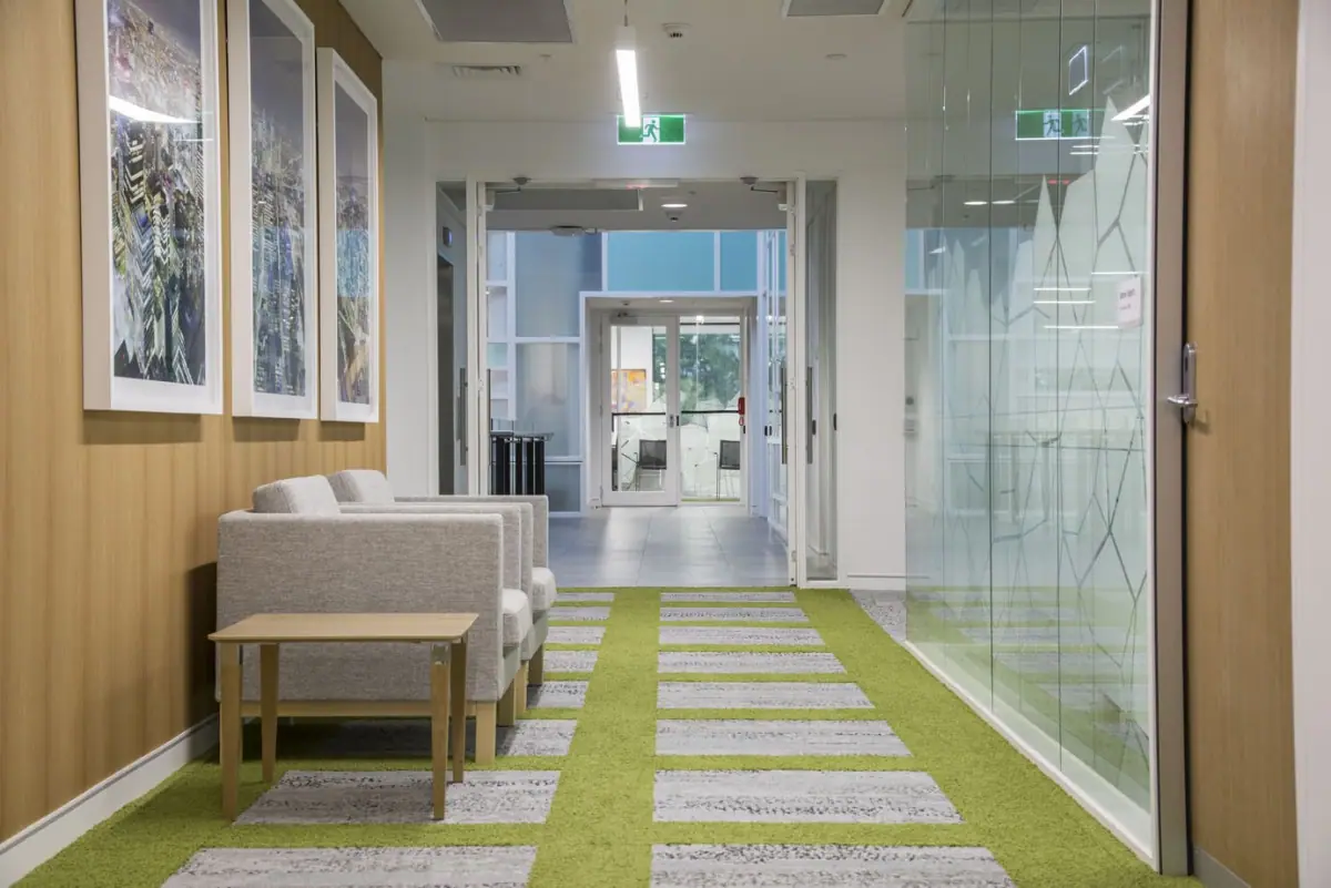 Gang met groene en grijze tapijttegels van Interface in een zakelijk gebouw