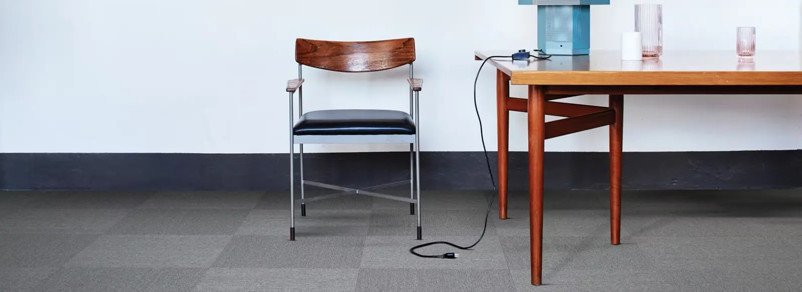 Interface-tapijttegels in grijs onder een houten tafel